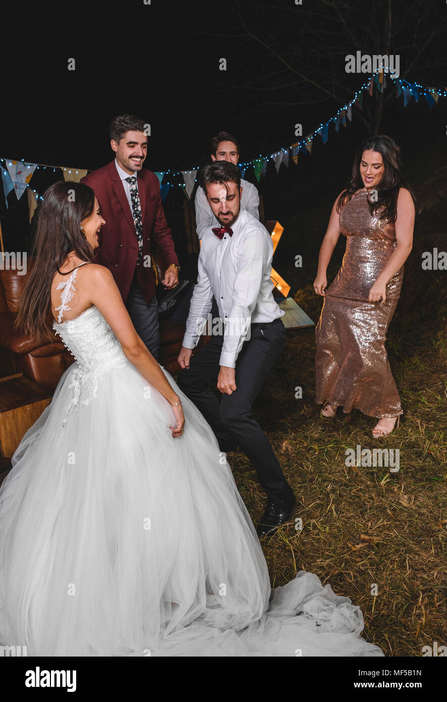 Glückliche Braut tanzen und Spaß mit Ihren Freunden auf einer Nacht Feld Partei Stockfoto