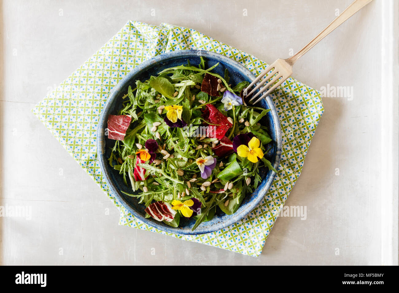 Schüssel mit Salat, Feldsalat, Rucola, Radicchio und essbaren Blüten Stockfoto