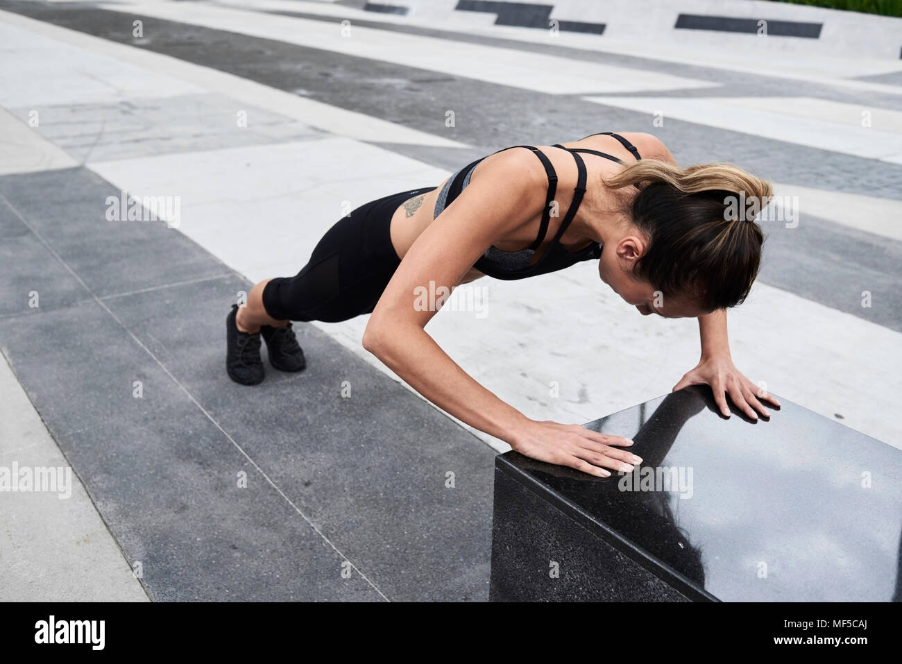 Passende Frau tun Push-ups im Freien Stockfoto