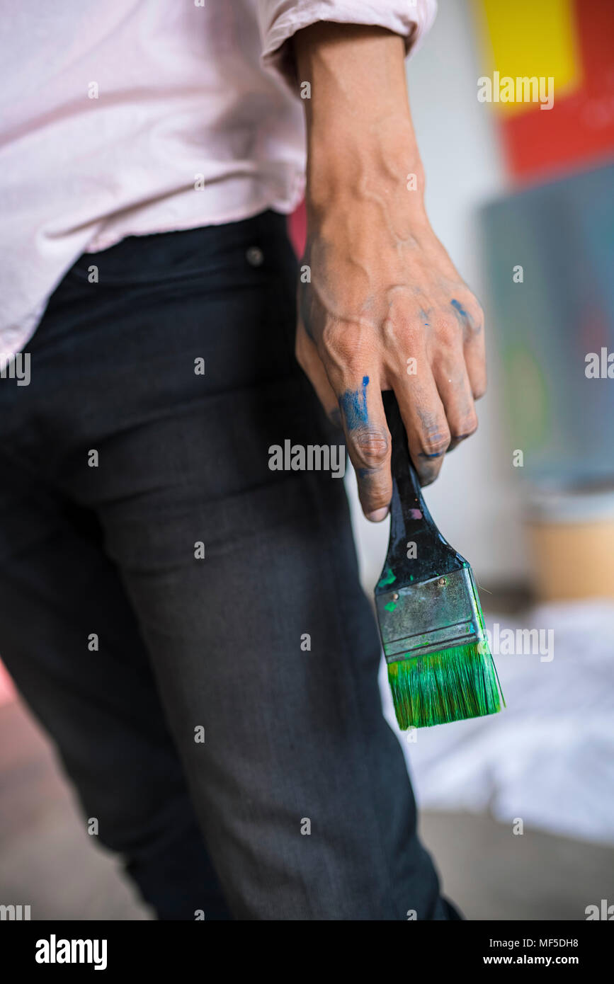 Detail der Künstler mit einem Besen mit grüner Farbe in einem Loft Studio Stockfoto