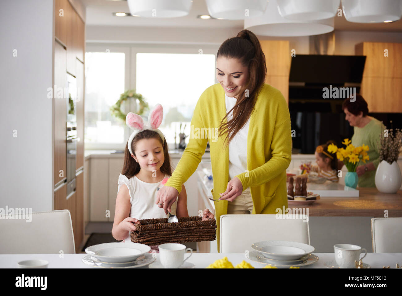 Lächelnde Mutter und Tochter, den Tisch zu hause zusammen Stockfoto