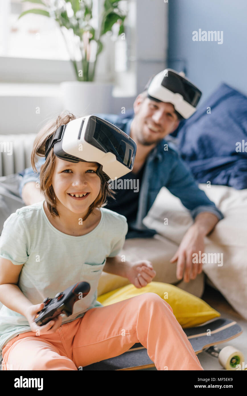 Portrait von Happy Boy und Vater tragen VR-Brille spielen video Spiel zu Hause Stockfoto