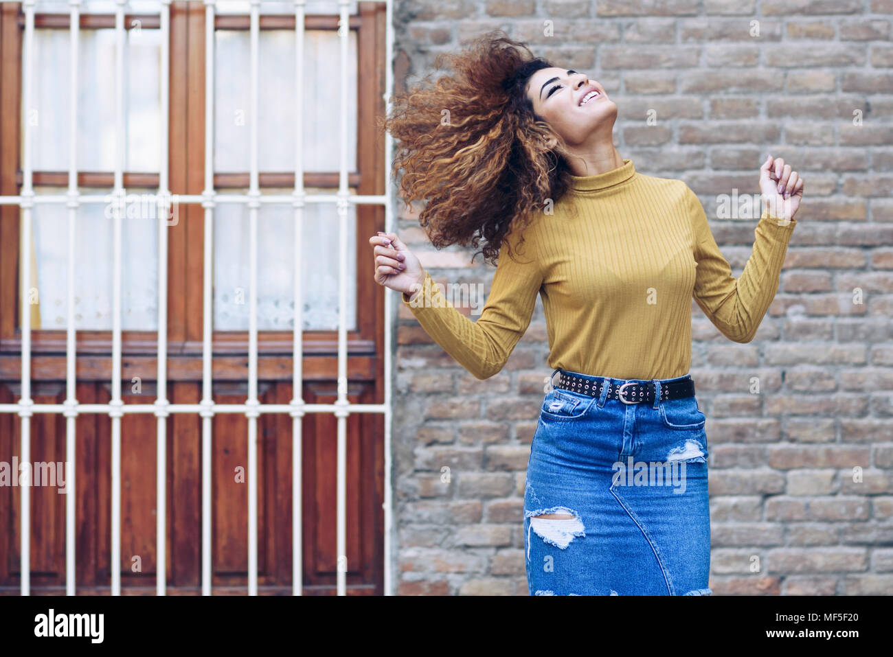 Spanien, Andalusien, Granada. Schöne junge Frau mit dem lockigen Haar frisur Bewegen im Freien. Lifestyle Konzept Stockfoto