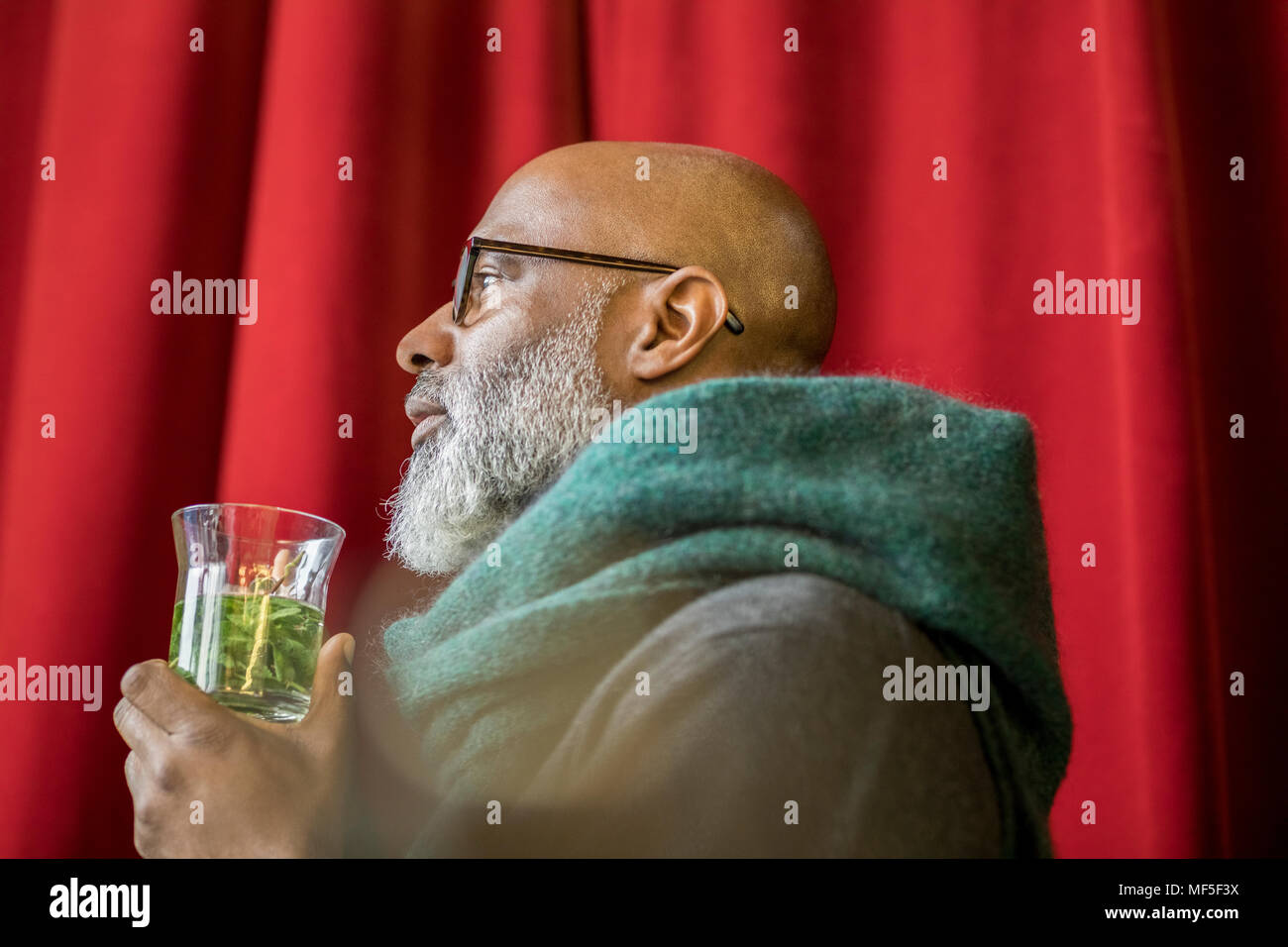 Profil von nachdenklicher Mann mit Glas Tee Stockfoto