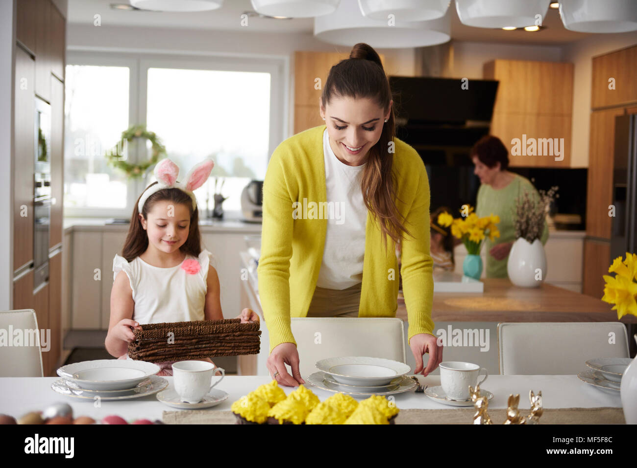 Lächelnde Mutter und Tochter, den Tisch zu hause zusammen Stockfoto