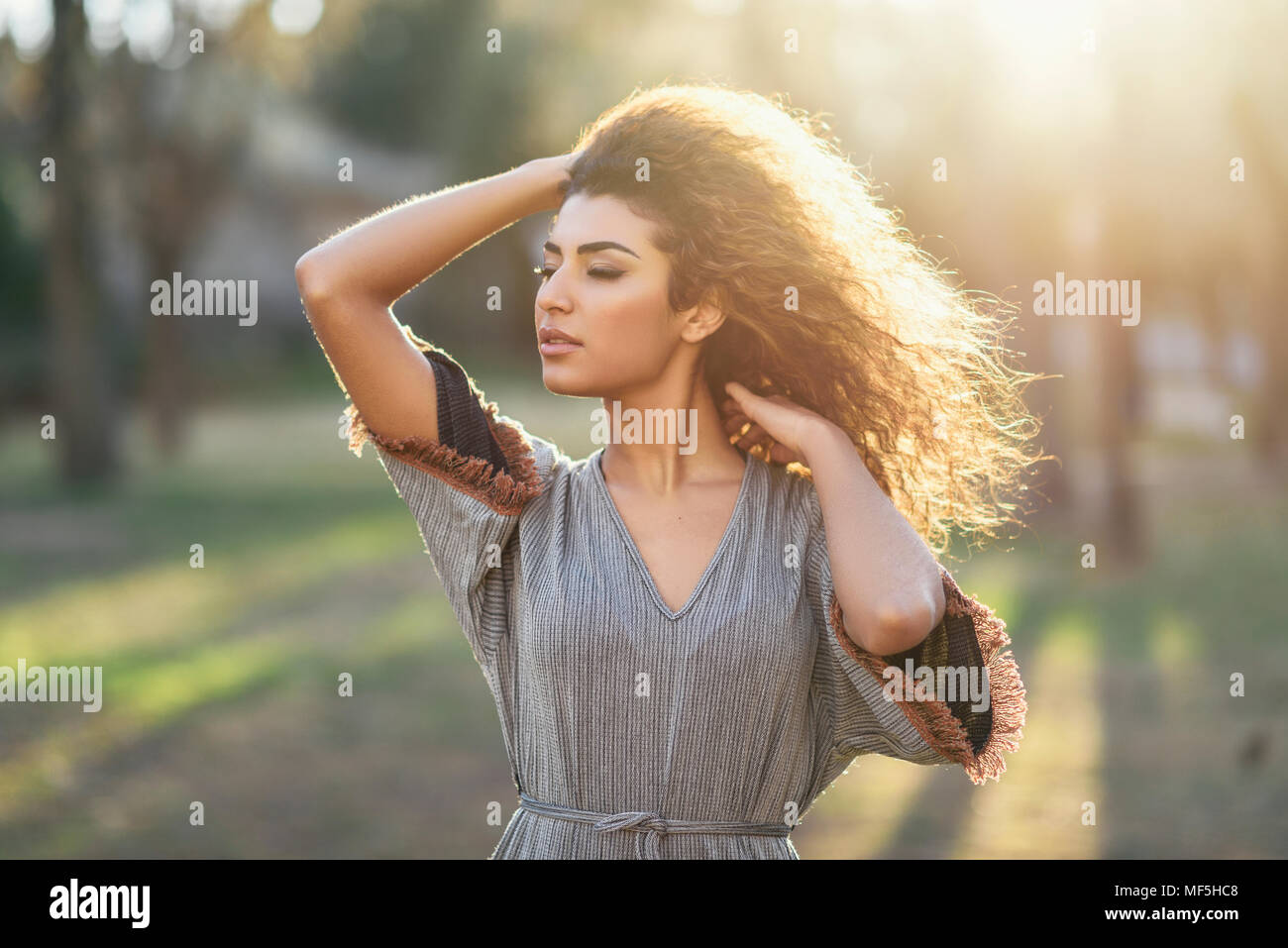 Spanien, Andalusien, Granada. Glückliche junge Frau mit Curly Frisur in einem städtischen Park mit geschlossenen Augen. Lifestyle Konzept. Stockfoto