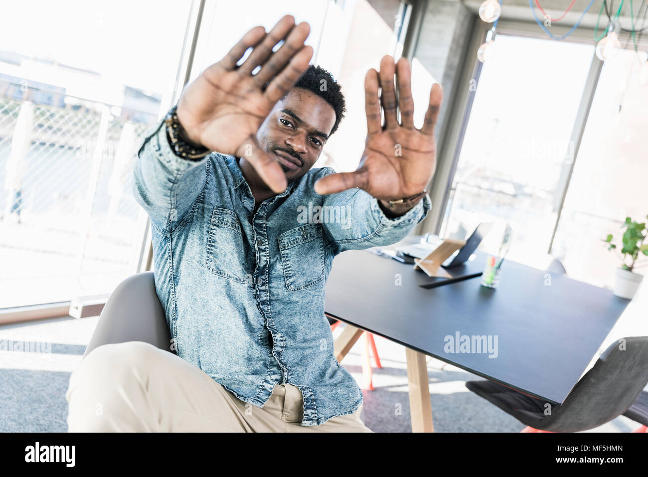 Portrait von lächelnden casual Geschäftsmann im Büro einen Finger frame Stockfoto