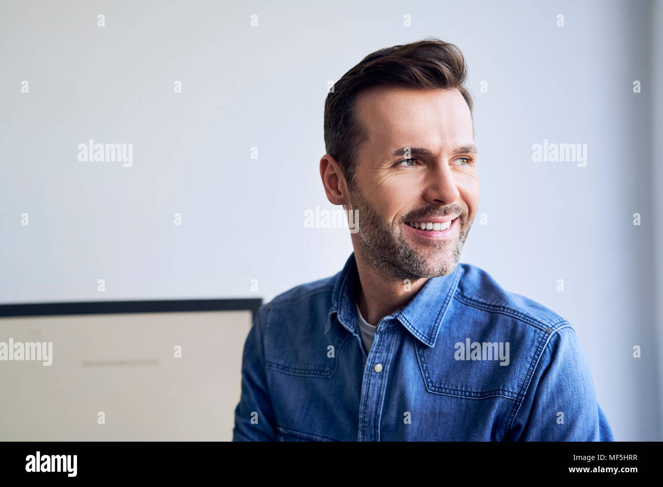 Portrait von lächelnden Mann im Amt seitlich auf der Suche Stockfoto