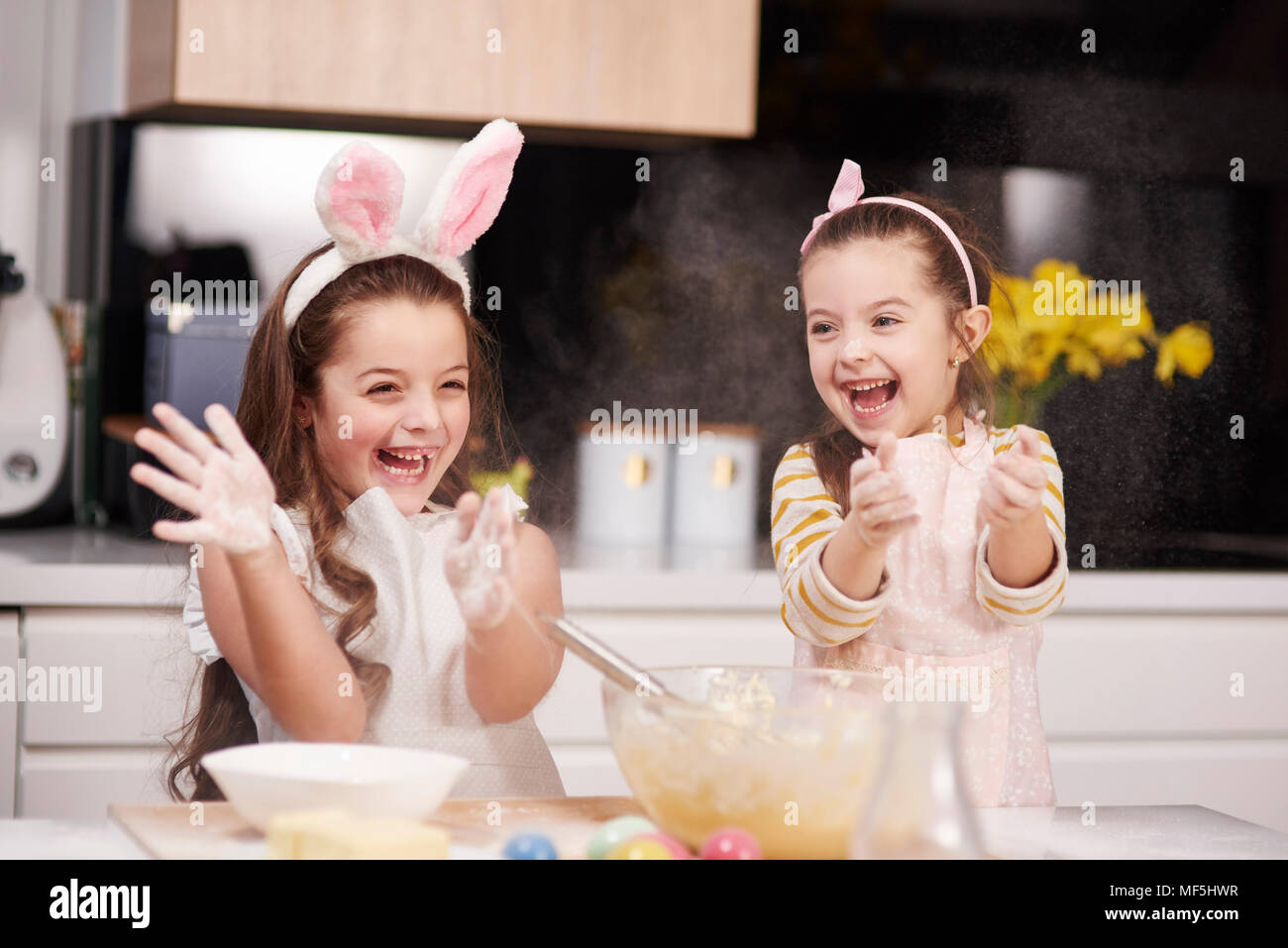 Zwei verspielten Schwestern gemeinsam Spaß backen Ostern Cookies in der Küche Stockfoto
