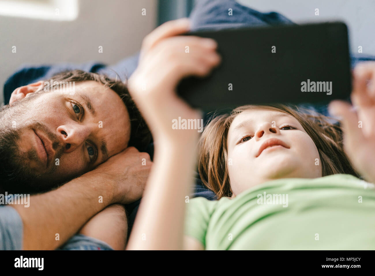Vater und Sohn betrachten gemeinsam zu Hause smartphone Stockfoto
