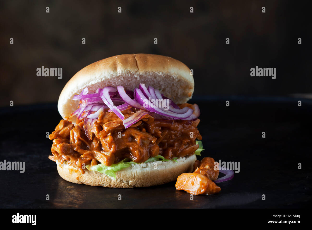 Burger mit Jackfruit Gulasch vor dunklem Hintergrund Stockfoto