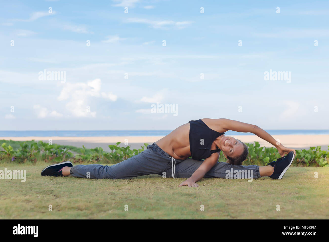 Indonesien, Bali, Frau Stretching Stockfoto