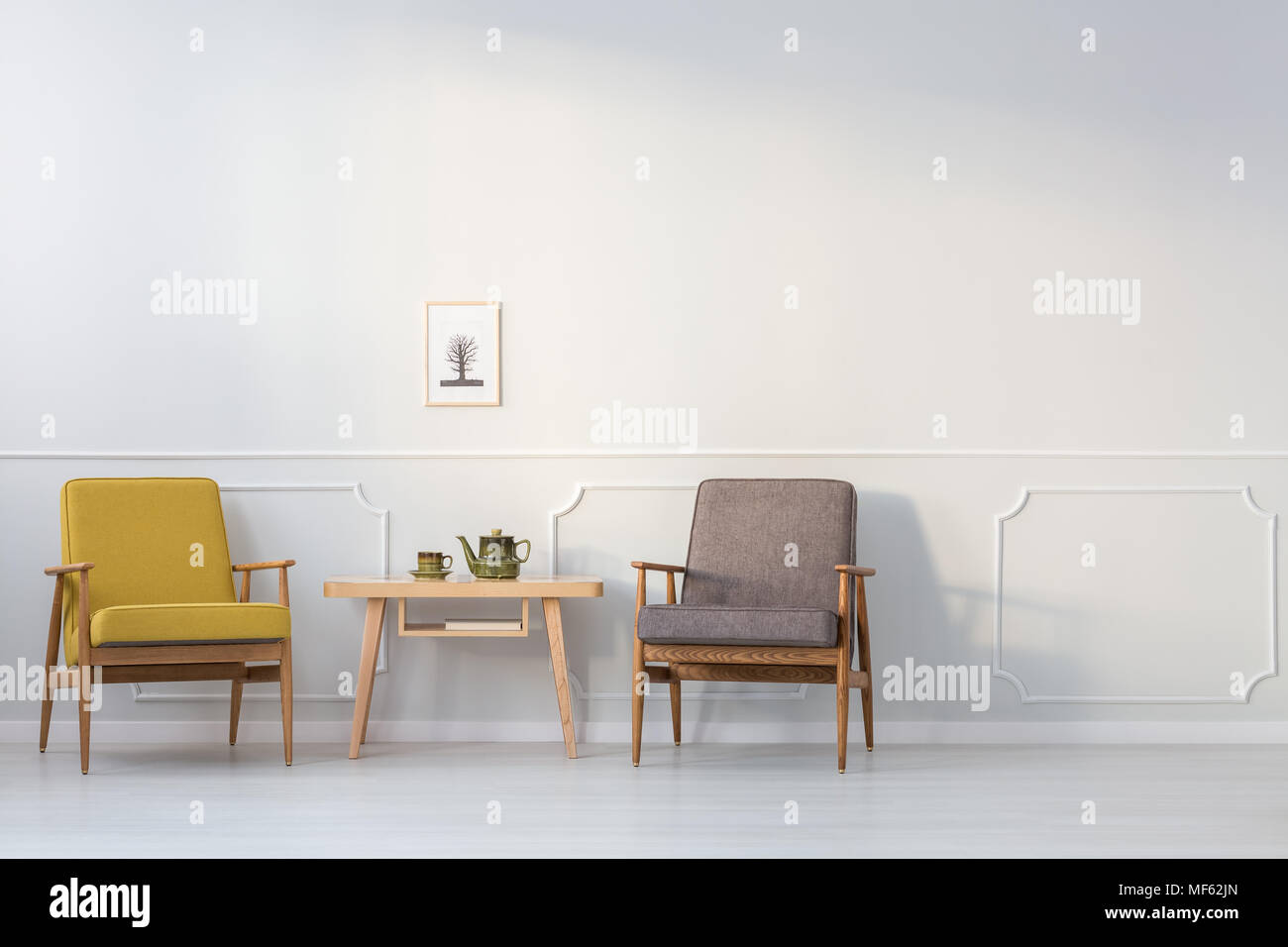 Holztisch Zwischen Gelb Und Grau Sessel Gegen Weisse Wand Mit