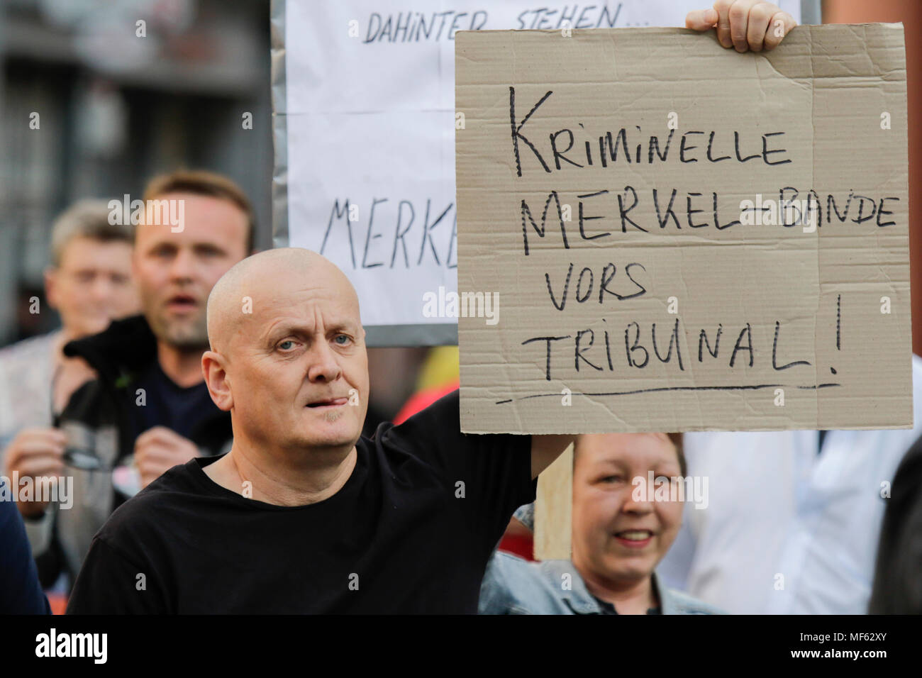 Mainz, Deutschland. 23 Apr, 2018. Ein rechter Demonstrant hält ein Schild mit der Aufschrift 'kriminellen Merkel fach Kleinkind von einem Gericht'. Rund 50 Rechtsextreme Demonstranten sammelten sich in der Innenstadt von Mainz, gegen die deutsche Regierung zu protestieren, für die Schließung der Grenzen und gegen Flüchtlinge unter dem Motto 'MErkel hat zu gehen'. Sie waren gehechelt, um rund 350 Zähler - Demonstranten. Quelle: Michael Debets/Pacific Press/Alamy leben Nachrichten Stockfoto