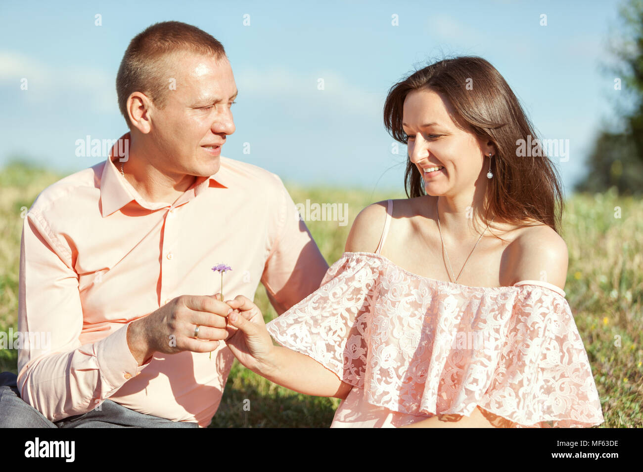 Porträt eines schönes Paar in der Liebe. Mann hält die Blume zu Frau. Stockfoto