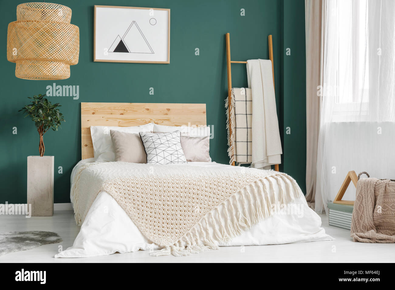 Anlage und Rattan Lampe grün gemütliches Schlafzimmer mit Bett aus Holz gegen die Wand mit Poster Stockfoto