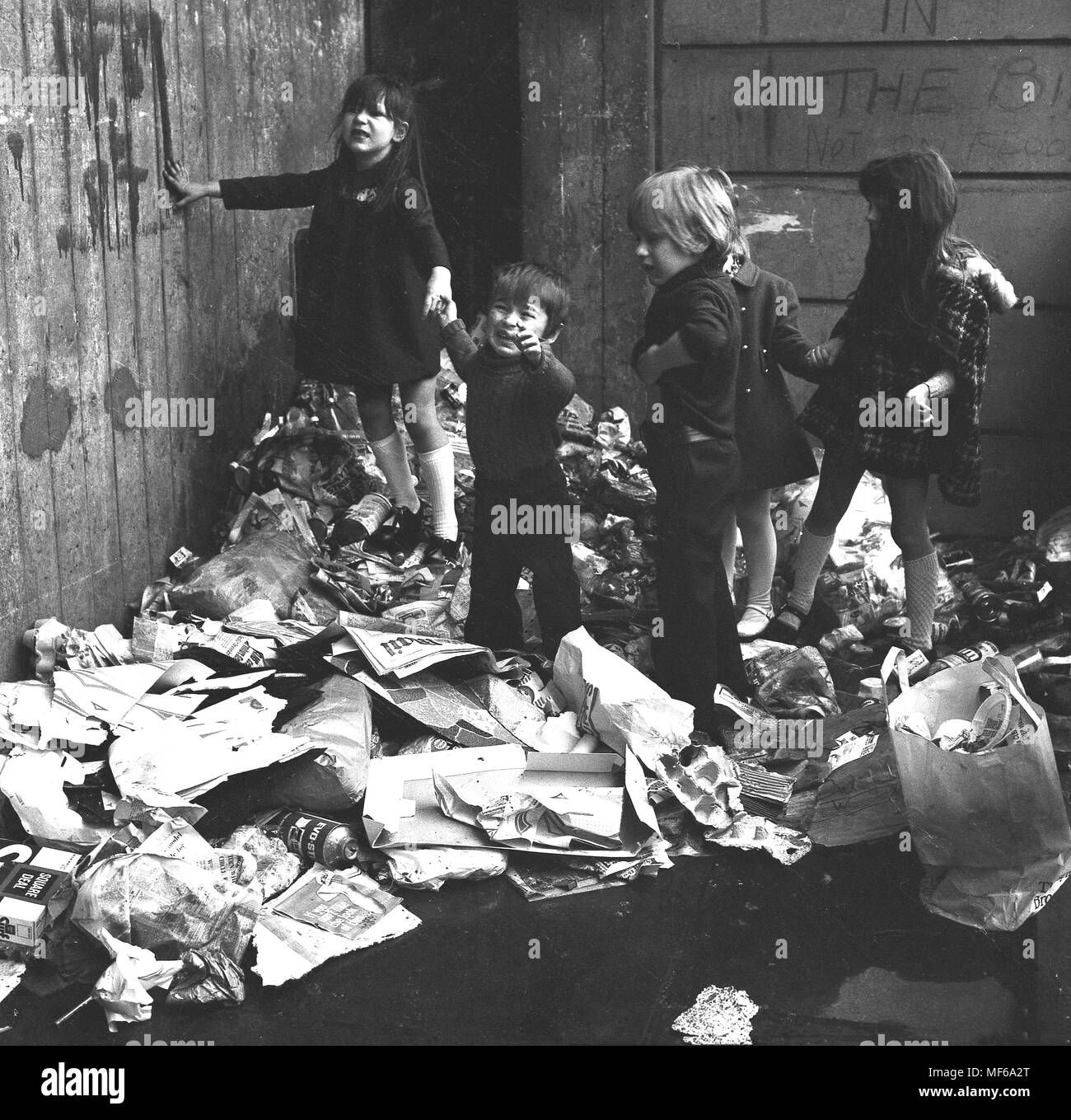 1972, historische Bild Kinder zusammen auf einem Haufen Hausmüll außerhalb, wo sie leben und spielen im Süden Londons. Der Junge ist gerade gestresst und unzufrieden. In den 1970er Jahren verbreiteten öffentlichen Sektor Arbeiter Streiks wurden ein gemeinsames Merkmal des britischen Lebens und weigern sich, war eines der Dinge, die nicht für die Wochen, die zu ernsten Umwelt und Fragen der öffentlichen Gesundheit gesammelt und für Kinder Gefahr beim Spielen im Freien. Stockfoto