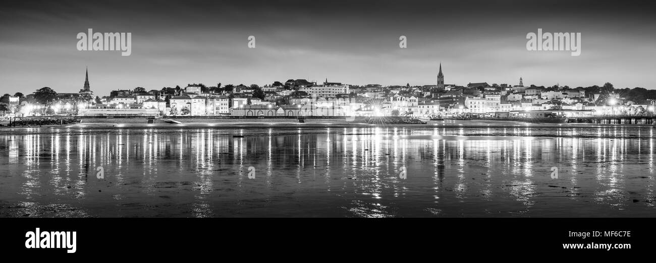 Schwarze und weiße Nacht Panorama einer Küstenstadt mit Lichtreflexionen im Meer Stockfoto