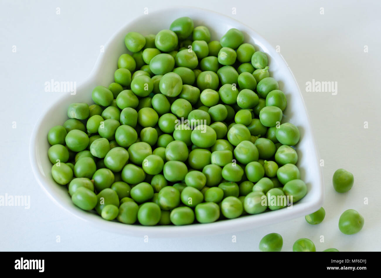 Frische grüne Erbsen Makro - biologische Lebensmittel in den weißen Teller. Stockfoto