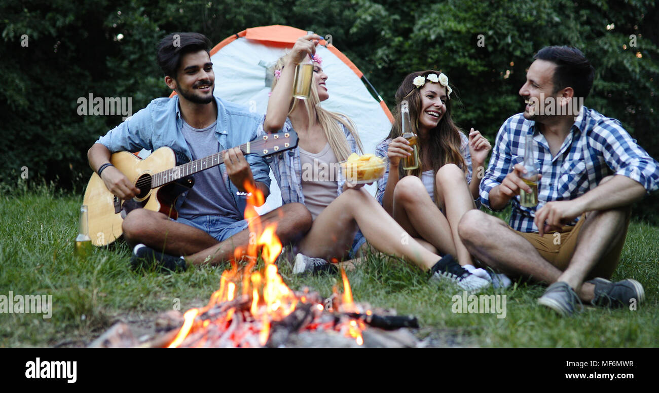 Gerne Freunde, Musik zu spielen und Lagerfeuer geniessen. Stockfoto