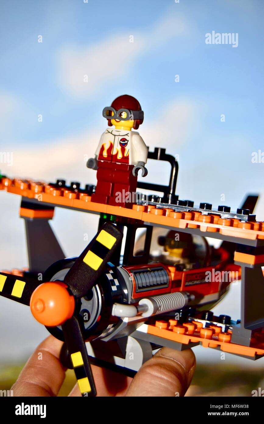 Lego Flugzeug bauen von einem Kind in der Luft gehalten werden um zu fliegen. Hintergrund Himmel. Stockfoto