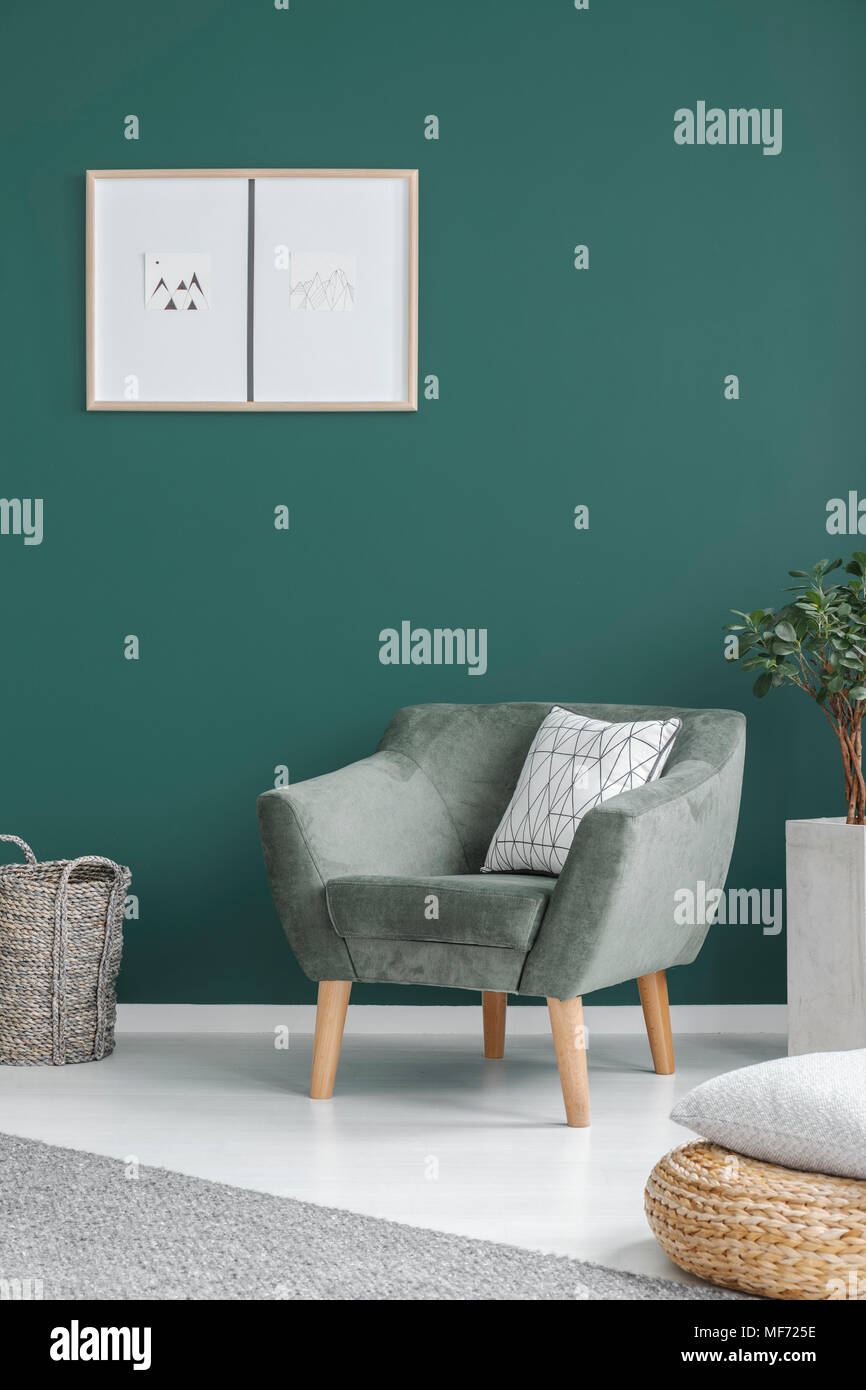 Anlage neben dem grünen Sessel mit Kissen in Wohnzimmer Interieur mit Poster an der Wand Stockfoto