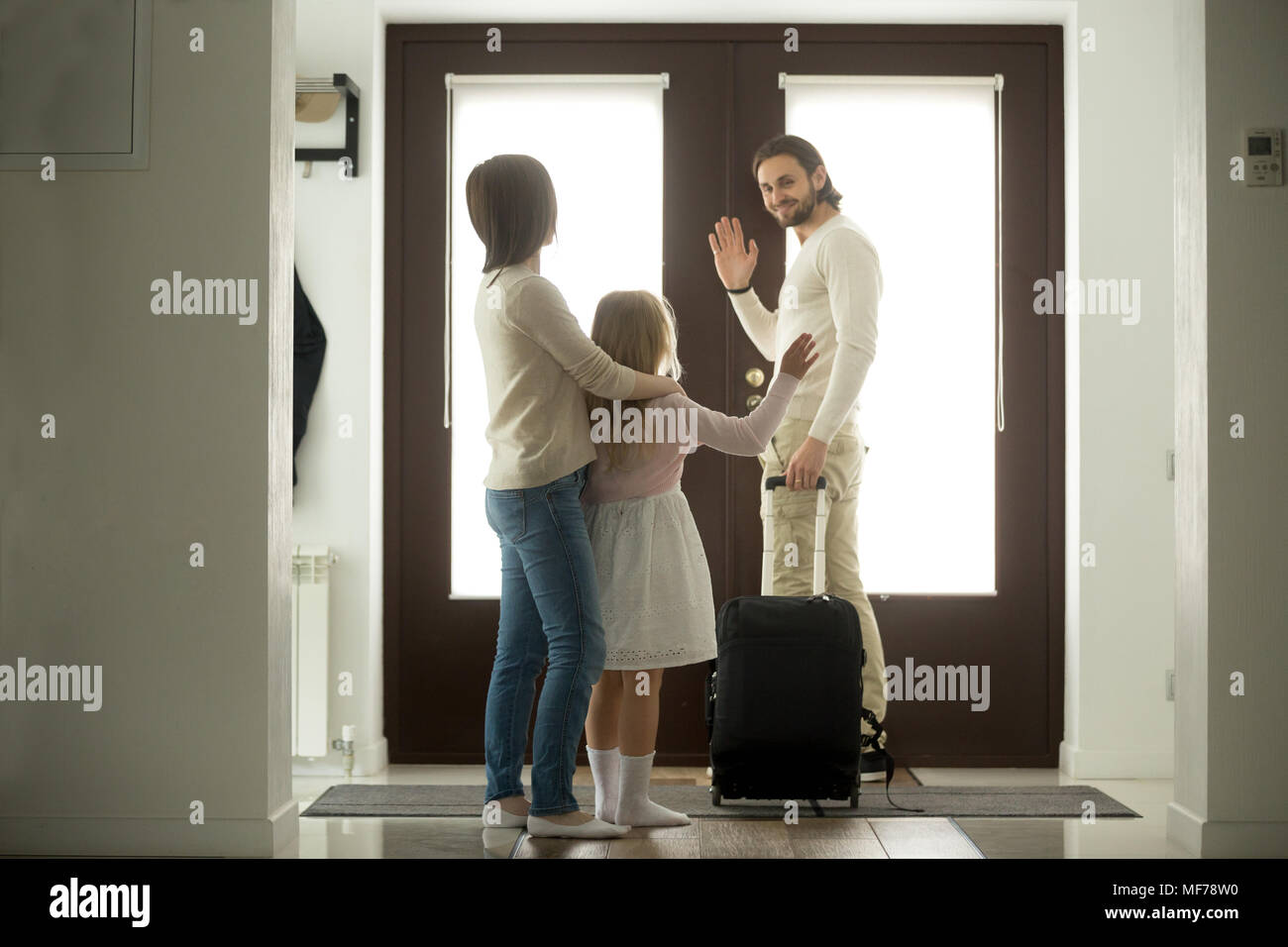 Lächelnd Vater Abschied von Frau und Tochter von zu Hause eine winkende Stockfoto