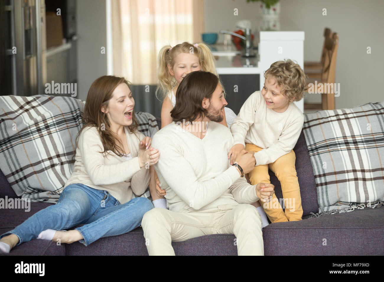 Kinder und Eltern lachen Spaß spielen Sitzen auf einem Sofa Stockfoto