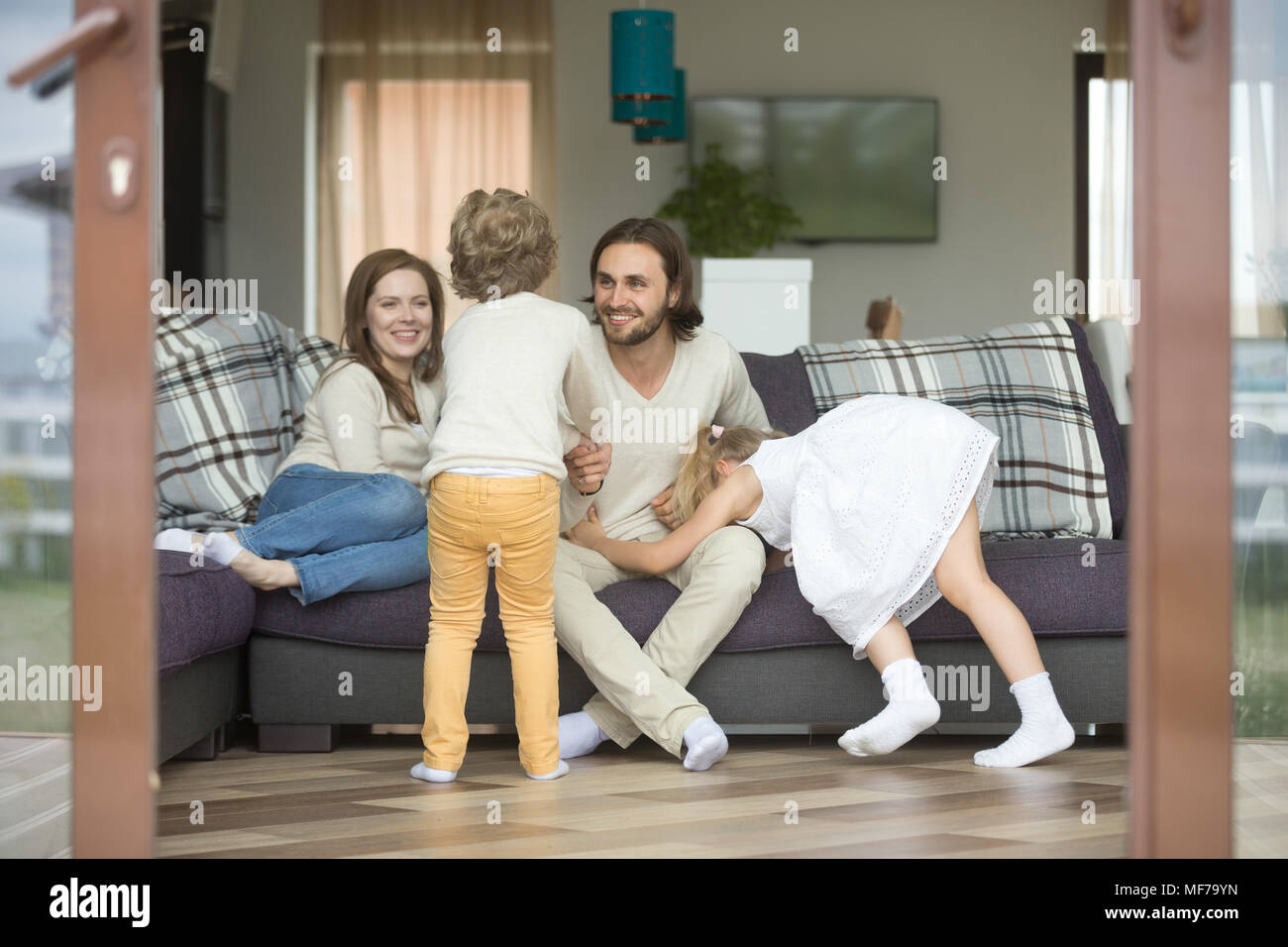 Glückliche Familie zu Hause spielen, Kinder, die Spaß mit den Eltern Stockfoto