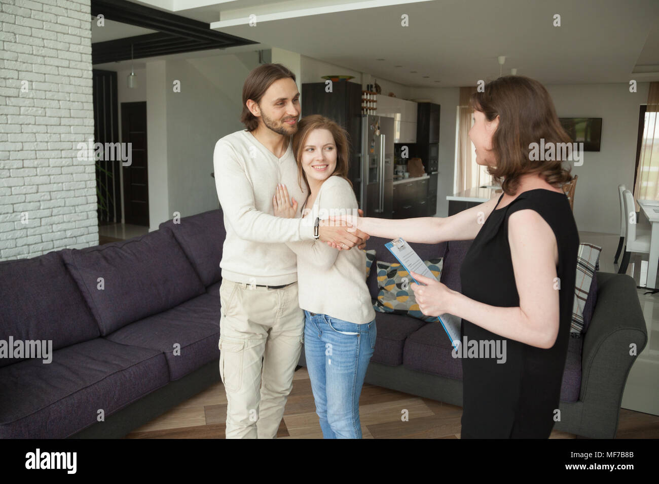 Lächelndes Paar handshaking Immobilienmakler Kauf oder Vermietung h Stockfoto