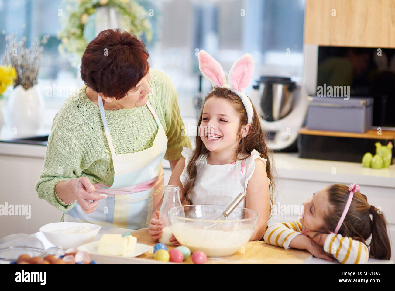 Großmutter und Enkelinnen backen Ostern Cookies in der Küche zusammen Stockfoto