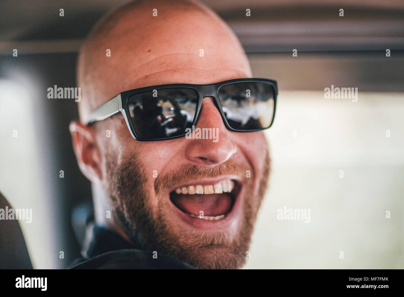 Porträt der glückliche junge Mann mit Sonnenbrille und Bart auf einen Road Trip Stockfoto