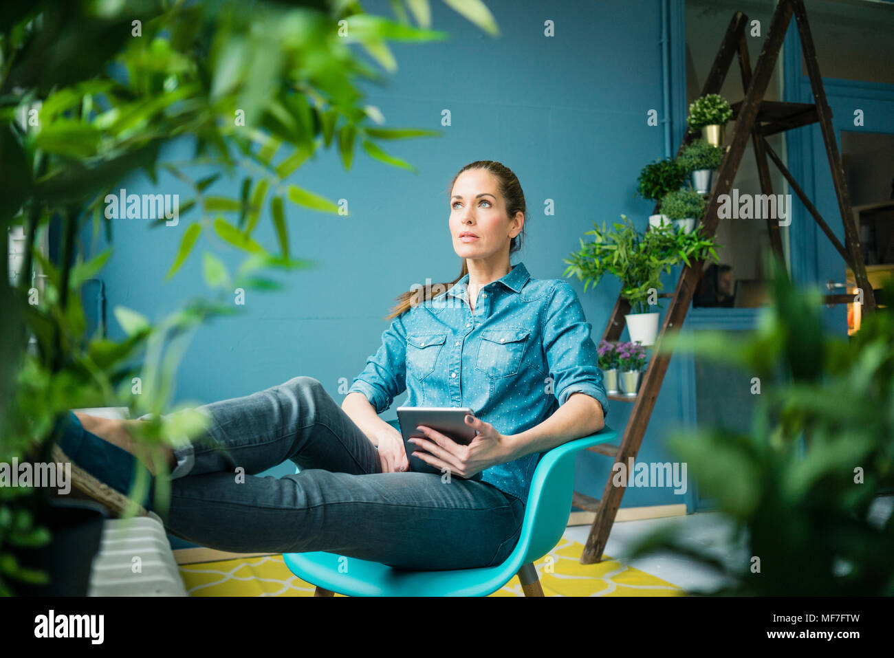 Schöne Frau in ihr Zuhause, mit Pflanzen dekoriert Stockfoto