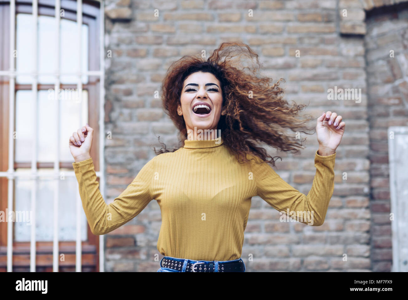 Spanien, Andalusien, Granada. Schöne junge Frau mit dem lockigen Haar frisur Bewegen im Freien. Lifestyle Konzept Stockfoto