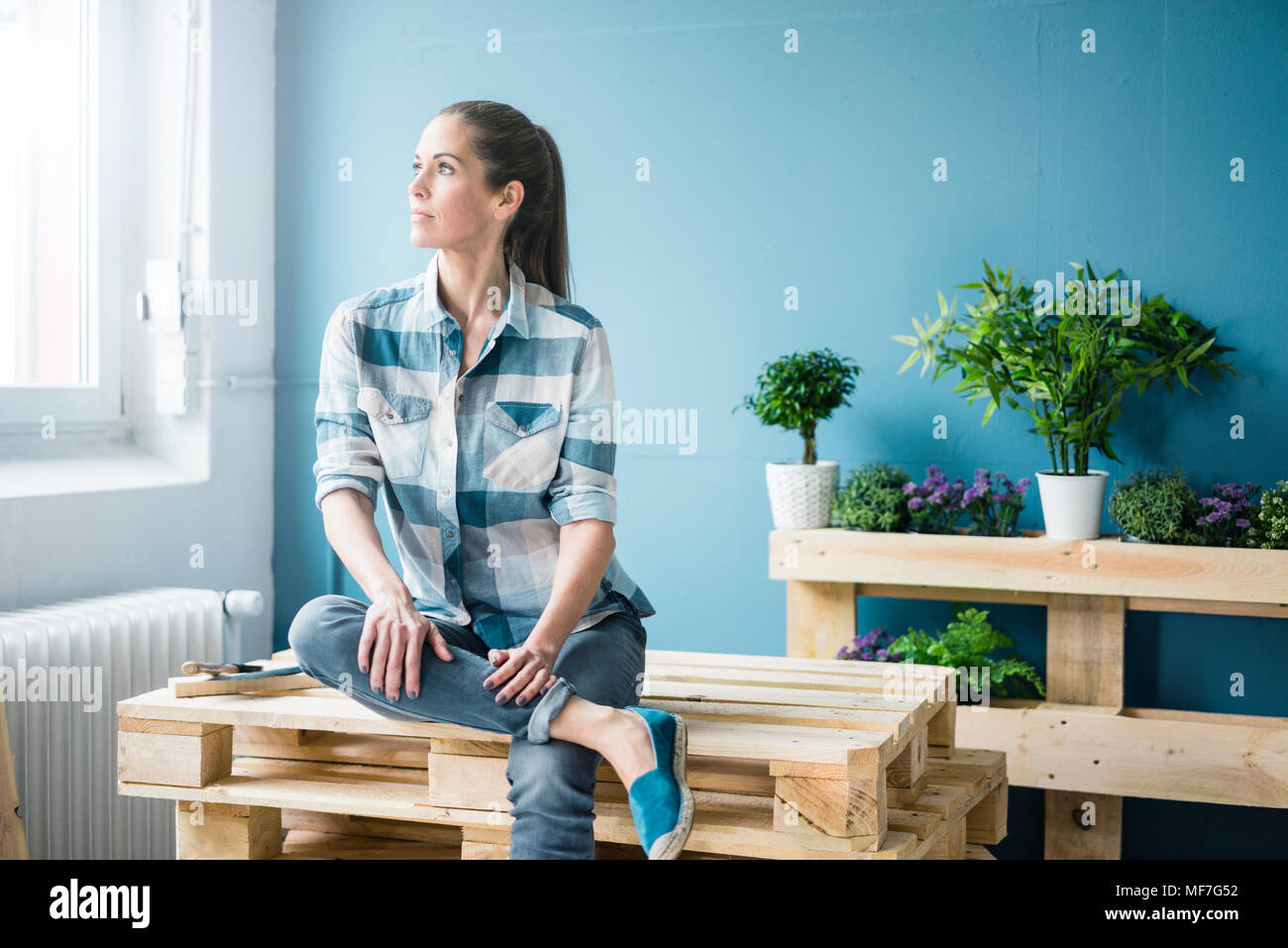 Schöne Frau planen ihr Haus mit Paletten zu sanieren Stockfoto