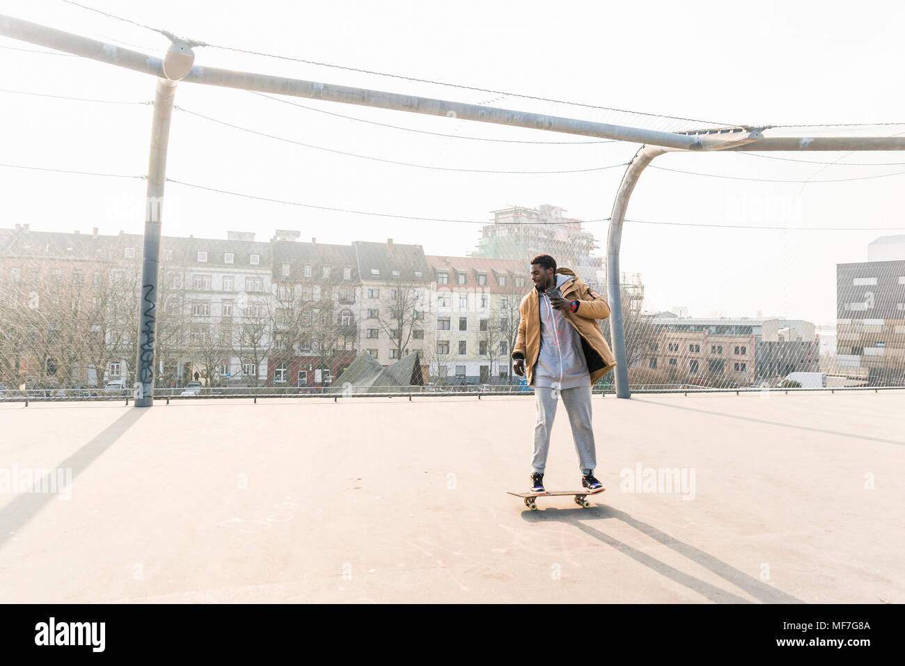 Junger Mann auf Skateboard auf Gericht Stockfoto
