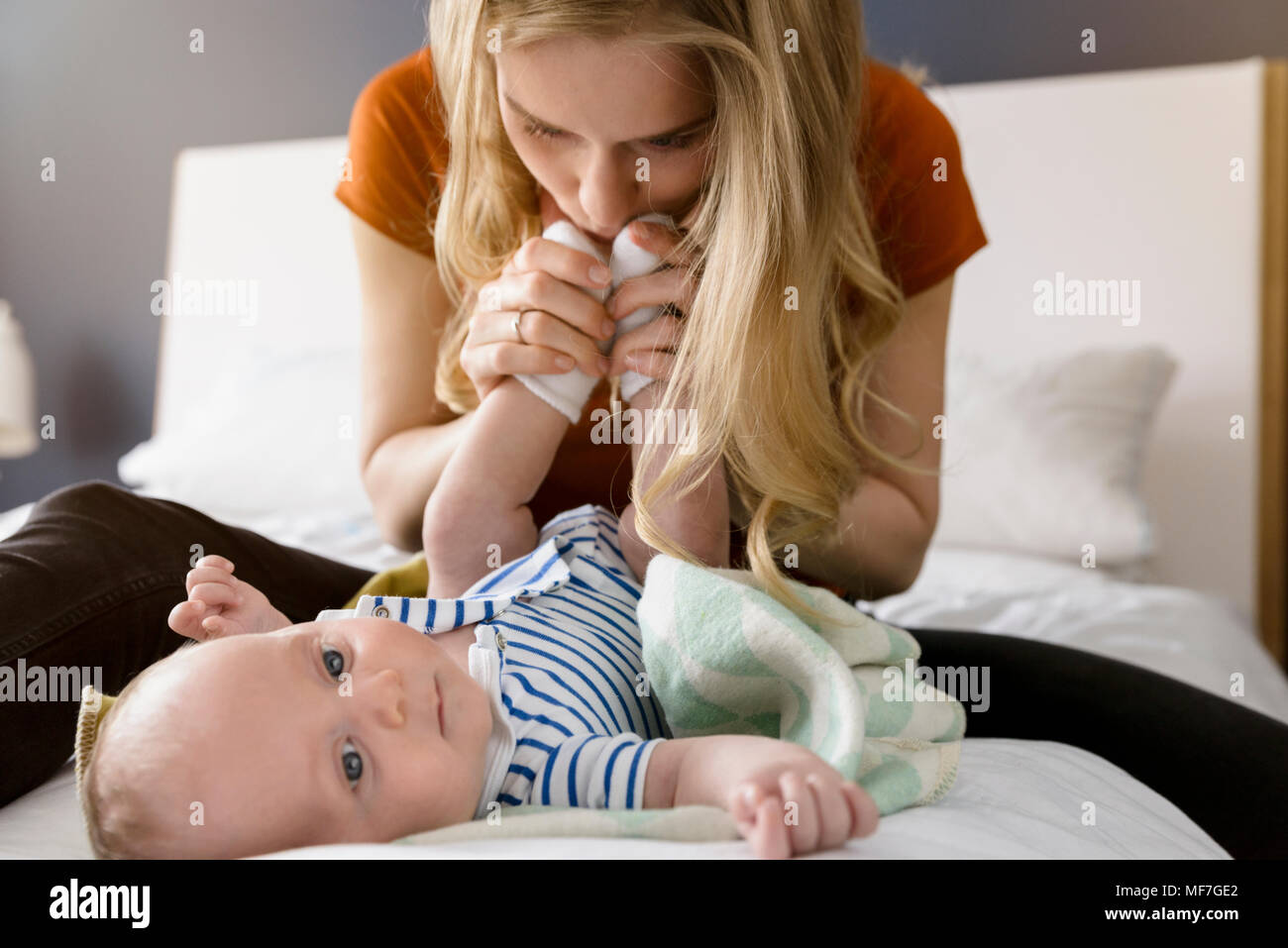 Mutter küssen Baby boy Füße Stockfoto