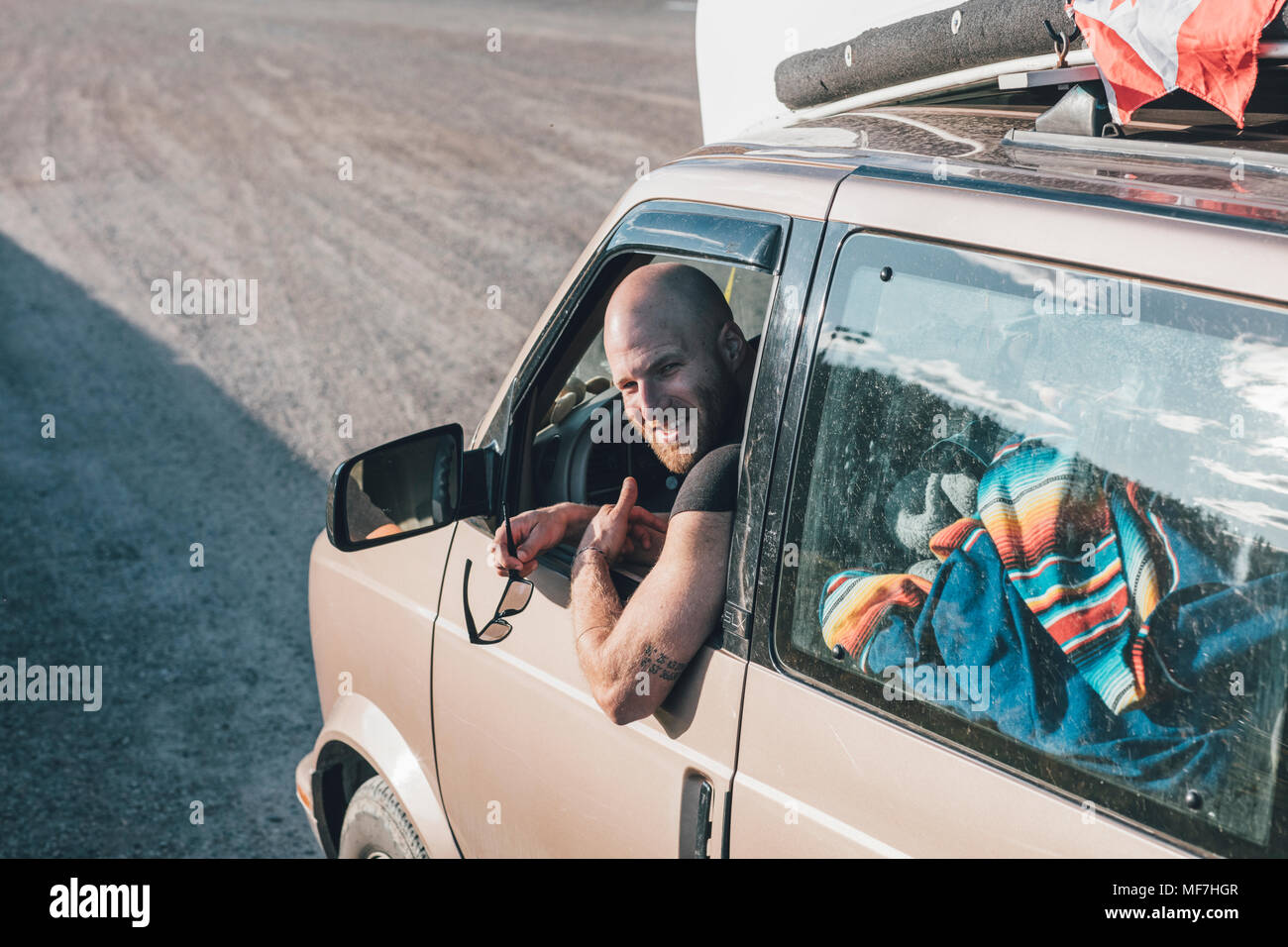 Porträt der glückliche junge Mann mit Minivan einen Road Trip Stockfoto