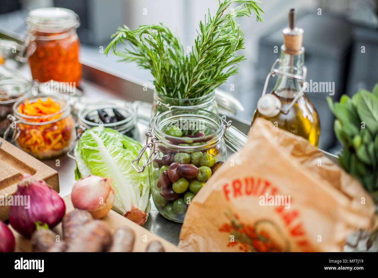 Verschiedene Zutaten, grüne Oliven im Glas Stockfoto