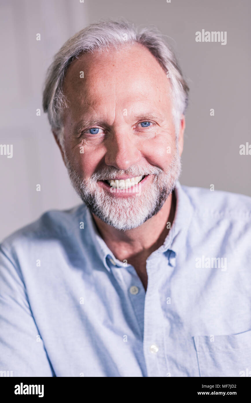 Portrait von Lachen reifer Mann mit blauen Augen und graue Haare Stockfoto