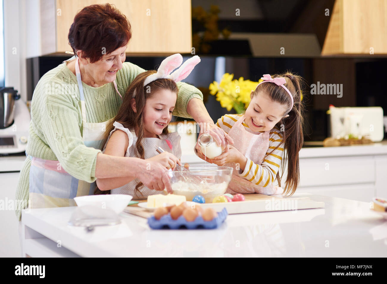 Großmutter und Enkelinnen backen Ostern Cookies in der Küche zusammen Stockfoto