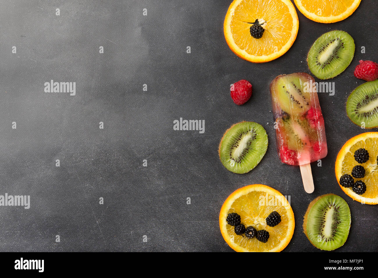 Beeren, fruchtschnitten und Kiwi berry Popsicle auf grauem Hintergrund Stockfoto