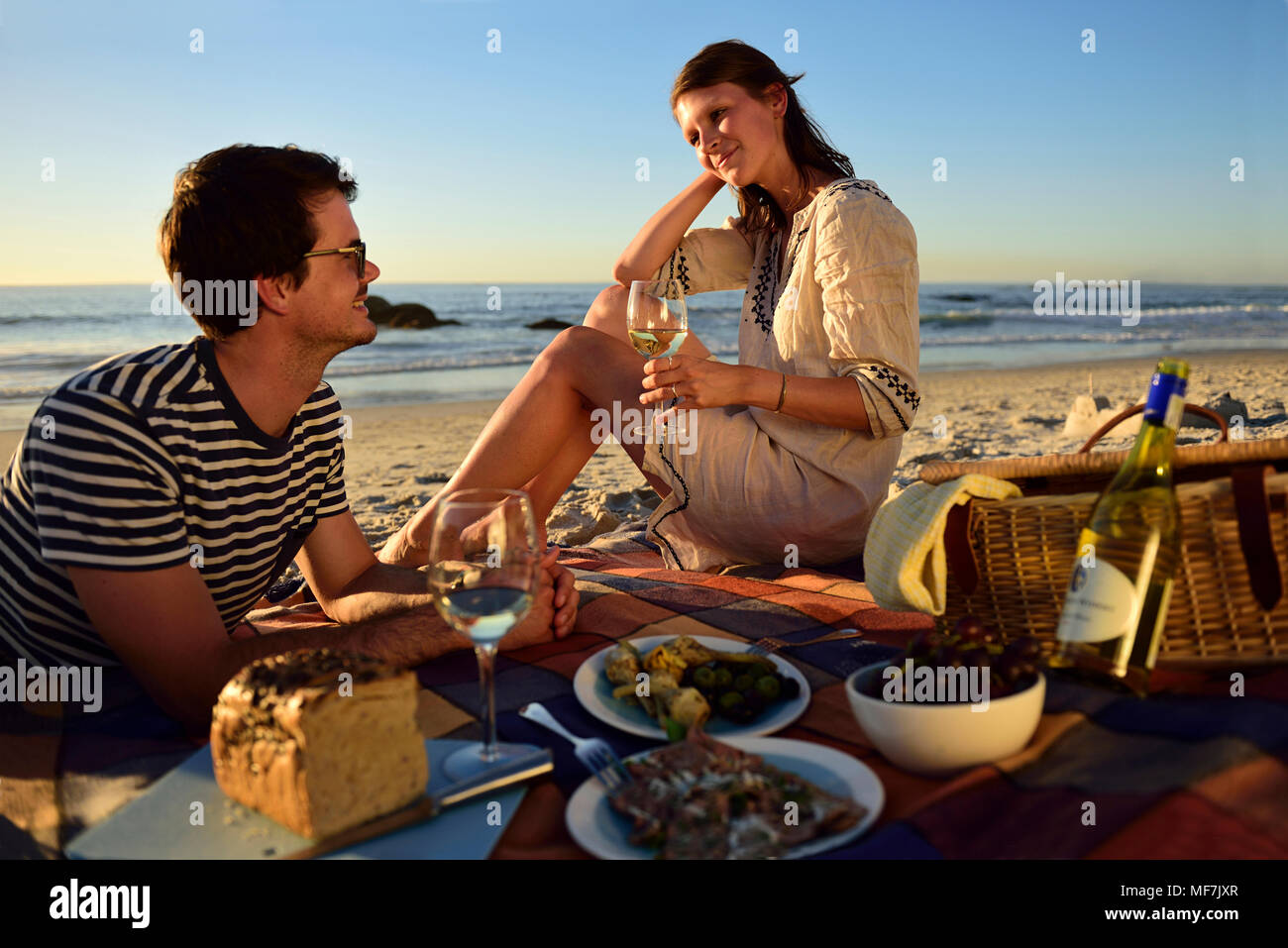 Glückliches Paar bei einem Picknick am Strand Stockfoto