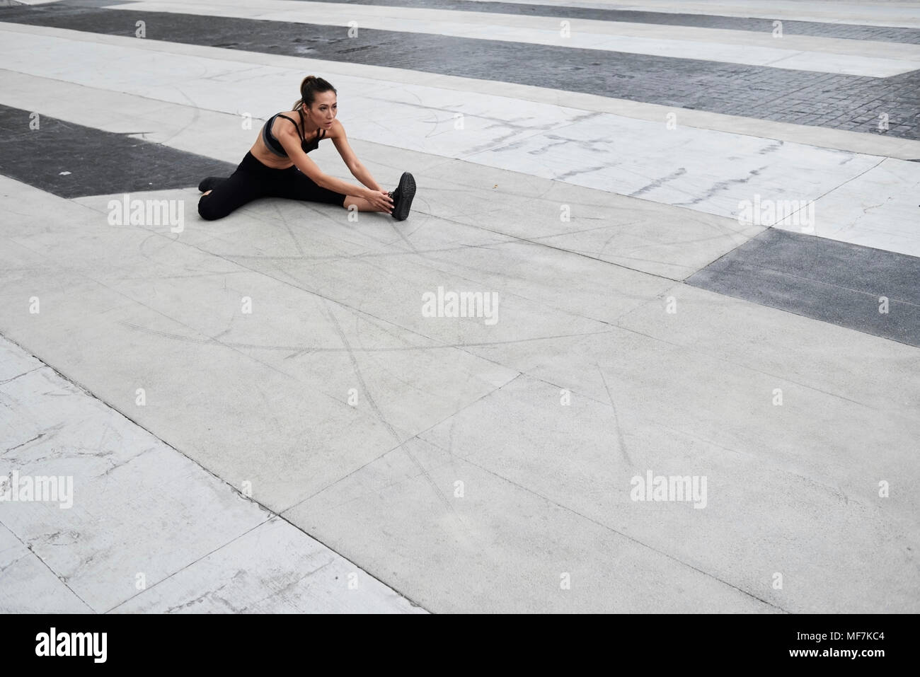 Passende Frau Stretching im Freien Stockfoto