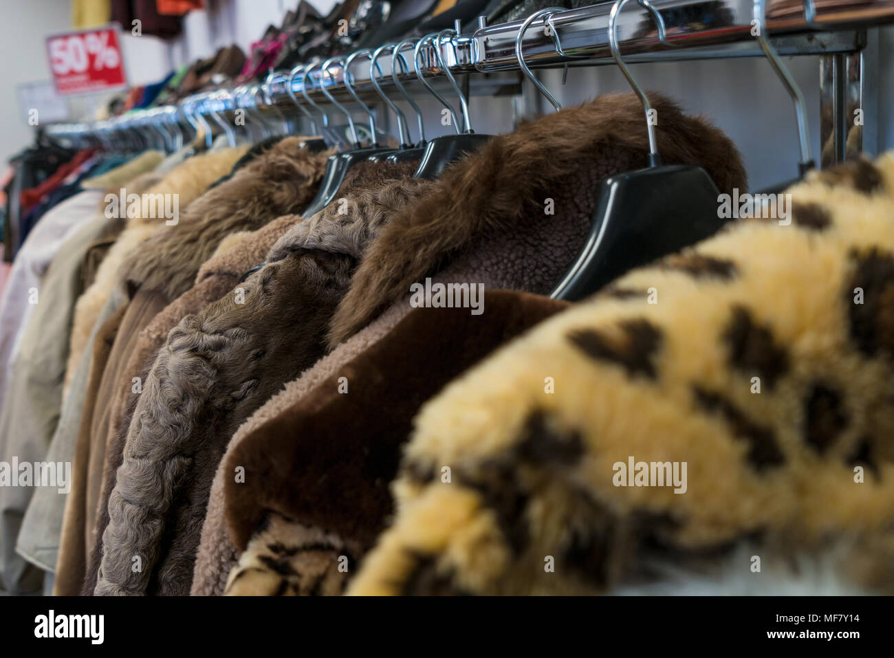 Schiene des gebrauchten Pelzmäntel für den Verkauf in einem Sparsamkeitspeicher oder Nächstenliebe Shop mit fünfzig Prozent Rabatt anmelden Stockfoto
