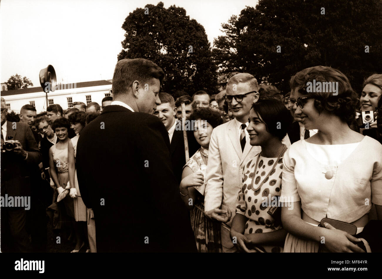 PX 65-2: 2 9 Aug 1962 Beschriftung auf der Rückseite: "Sechs hundert und drei Friedenskorps Auszubildende in Washington vorbereiten für Auslandseinsätze besucht Präsident Kennedy auf den Rasen des Weißen Hauses. Der Präsident begrüßte die Teilnehmer mit besonderer Freude, denn sie hatten sich verpflichtet, ein großes Abenteuer.", wiederholte er seine Hoffnung, dass Peace Corps Freiwilligen zu Karriere im Dienst der Regierung zurückkehren würde. Nach informellen Gespräch mit den Auszubildenden, der Präsident spontan bestellt eine spezielle Tour des Weißen Hauses für die Auszubildenden." Stockfoto