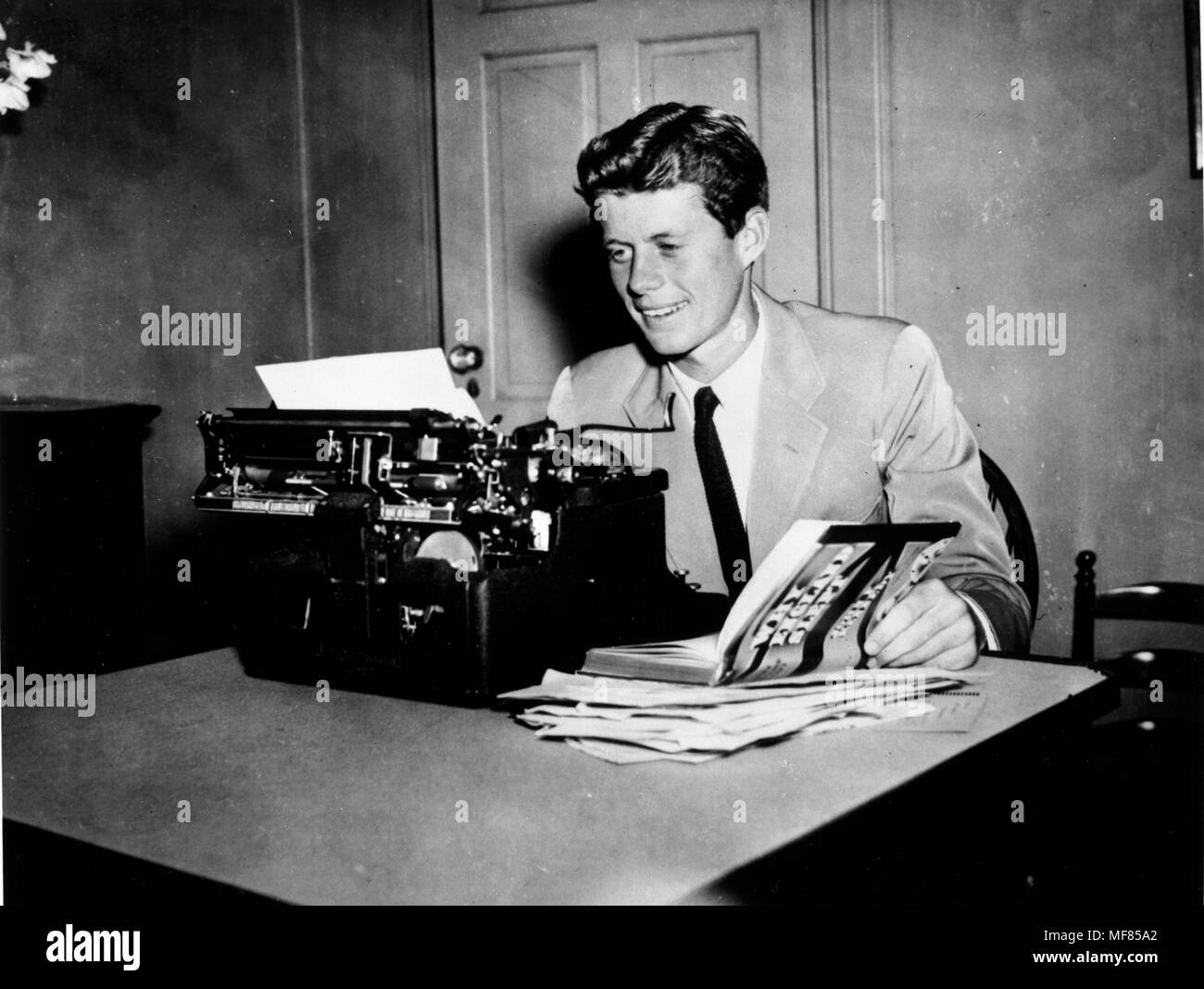 NLK 93-49 P27 Ca. 1940 John F. Kennedy bei einer Schreibmaschine mit seinem Buch "Warum England geschlafen." Bitte schreiben Sie 'John F. Kennedy Presidential Library und Museum, Boston' Stockfoto