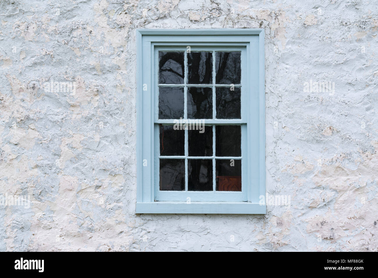 Alte Blaue Fenster auf einem Stein weiß getünchten Häuschen Stockfoto