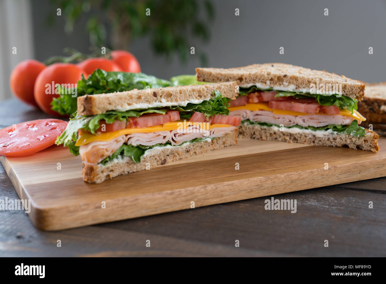 Die Türkei, Käse, Tomate Sandwich mit Salat auf einem Schneidebrett Stockfoto