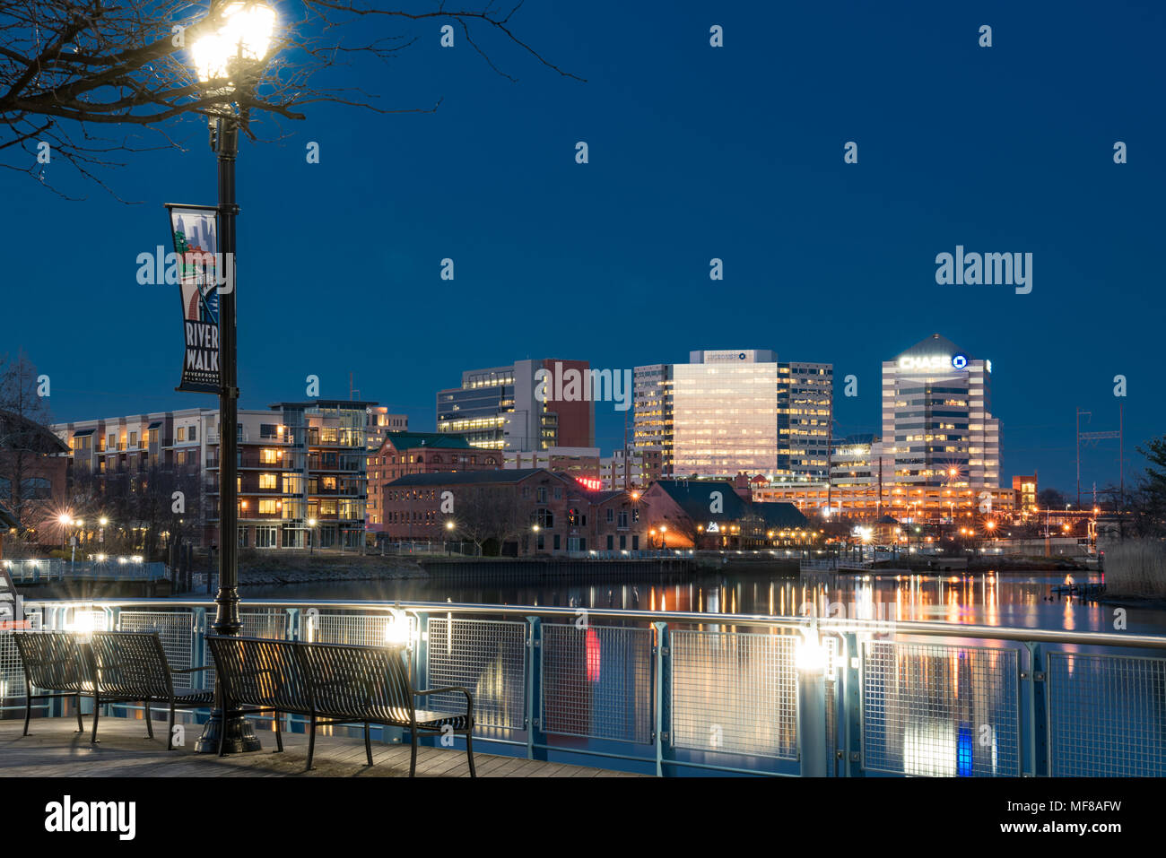 WILMINGTON, DE - April 5, 2018: Wilmington, Delaware Riverwalk und Skyline entlang der Christiana River bei Nacht Stockfoto